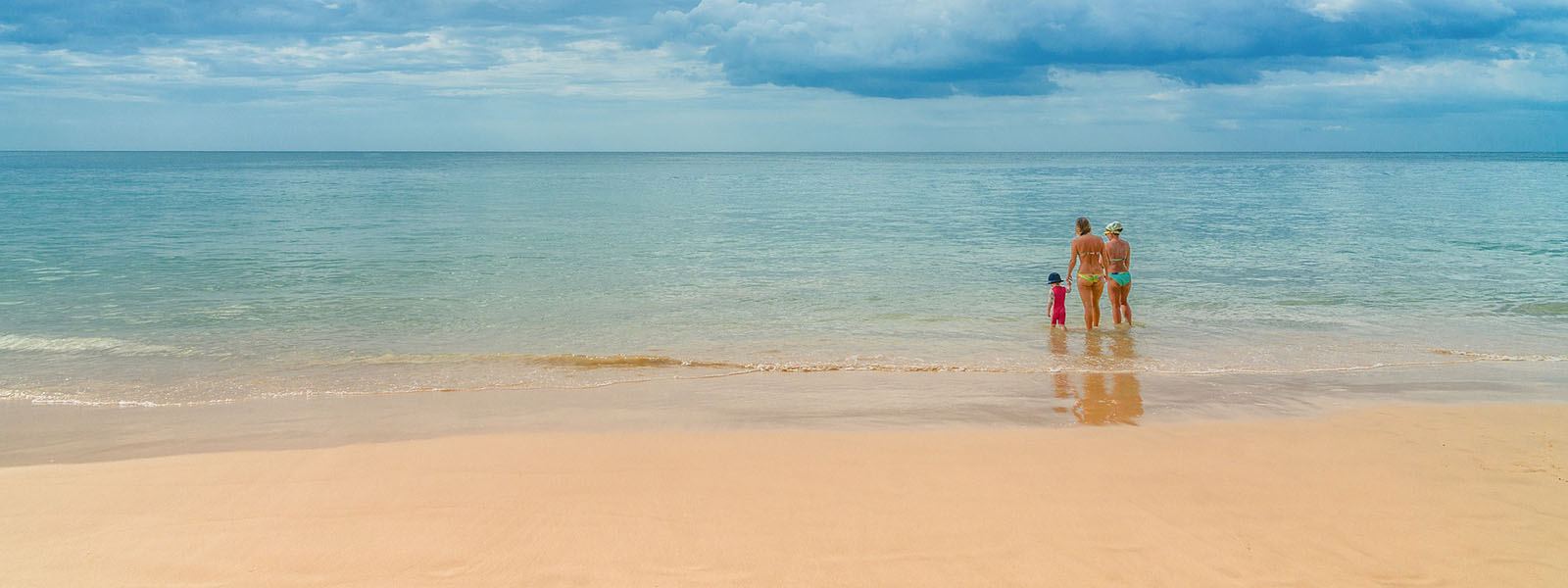 Family walking on a beach after Uganda family safaris